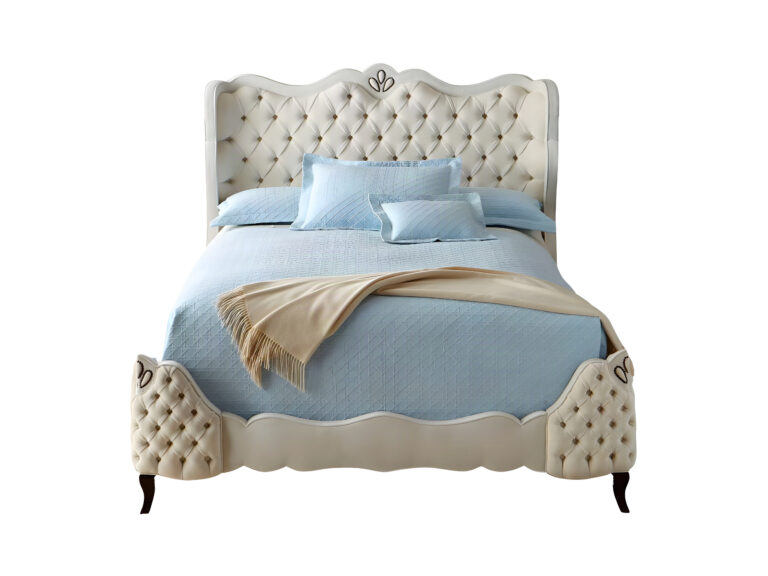 A Cama Estofada Carlisle AD Boutique exibe cabeceira alta em capitonê, moldura clara, estofamento premium e roupa de cama azul.