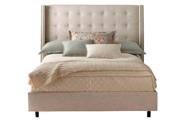 A Cama Estofada Fany AD Boutique exibe estrutura bege com cabeceira alta em capitonê premium, colchão nude e almofadas exclusivas.