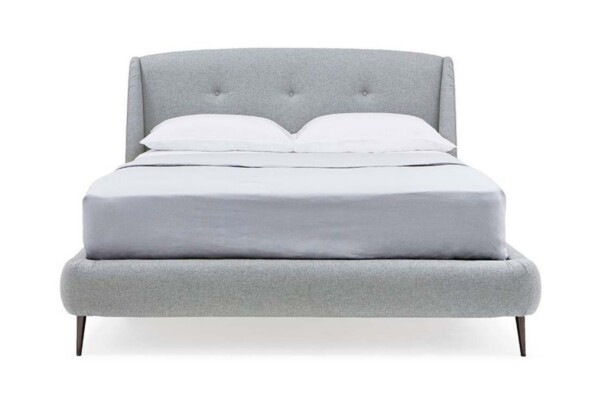 A Cama Estofada Joana da AD Boutique exibe design moderno com acabamento capitonê sofisticado e estofamento premium em cinza.