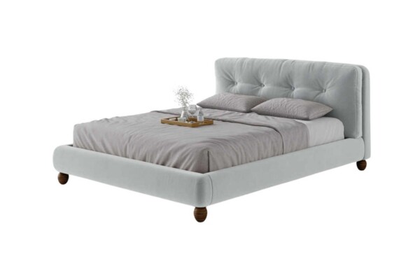 Cama estofada AD Boutique com cabeceira capitonê premium, enxoval cinza claro e bandeja de madeira nobre com peças decorativas.